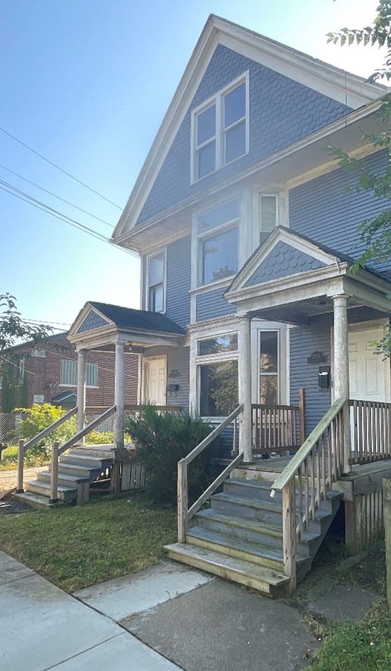 A duplex house with blue wood siding 