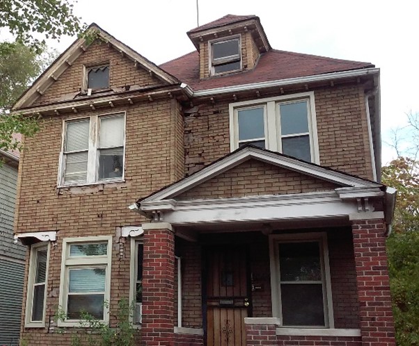 A house with brown asphalt siding on its gable