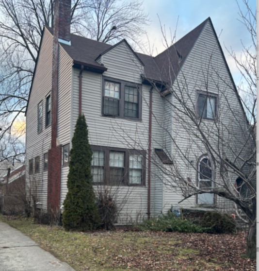 A picture of a house framed 45 degrees with white vinyl siding 