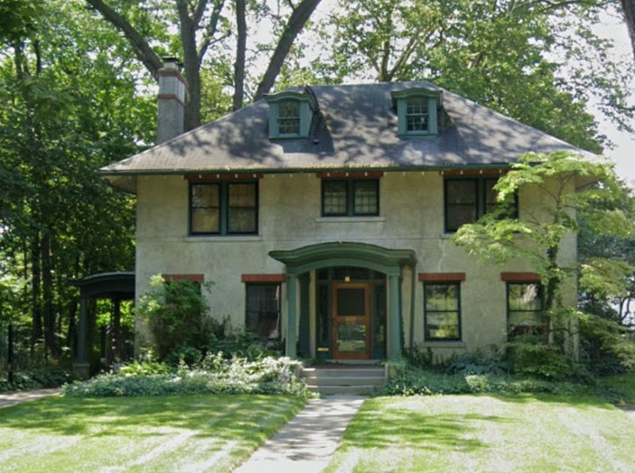 A 2-story house with a white stucco gable 